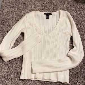 a white v-neck tight long sleeve knit top